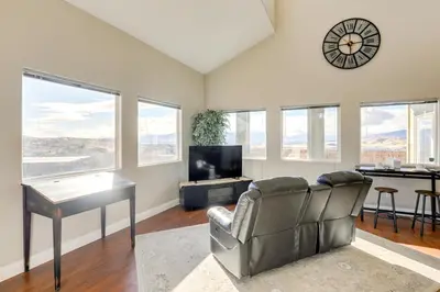 a living room with a couch and a table and a clock at Mtn-View Haven with Hot Tub! 28 Mi to Mt Rose Ski in Sparks