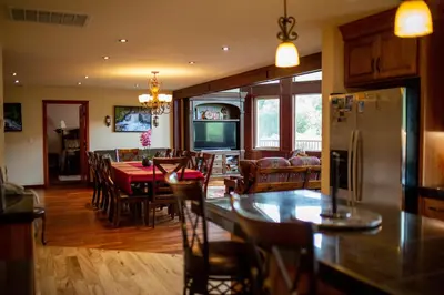 a kitchen and dining room with a table and a refrigerator at Waterfall Lodge near Yosemite Endless Pool, Hot Tub, Playground in Oakhurst