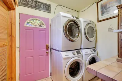 a pink door in a laundry room with a washer and dryer at Steps to Truckee River Walk Rose Cottage in Reno