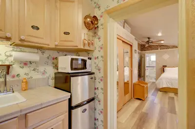 a kitchen with a refrigerator and a bedroom with a bed at Close to Midtown! Cozy Reno River Cottage in Reno