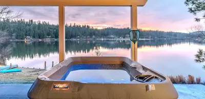 a bath tub sitting next to a body of water at Lakefront Villa with 180 degree view private dock and boats in Groveland
