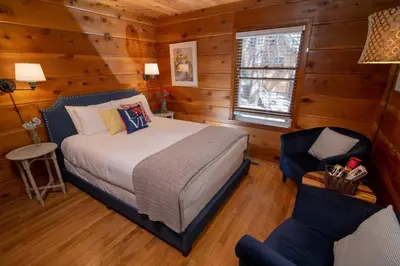 a bedroom with a bed and a chair in a room at Elliott House Boutique Inn in Shaver Lake