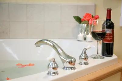 a sink with a bottle of wine and a wine glass at Elliott House Boutique Inn in Shaver Lake