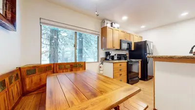 a kitchen with a wooden table and a large window at Meridian Villas #10 condo in Mammoth Lakes