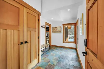 a hallway with wooden doors and a tile floor at Stunning Mountain Gem with Hot Tub Near Palisades in Olympic Valley