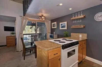 a kitchen with a stove and a counter top at Ski Den - Steps to Mammoth Village! in Mammoth Lakes