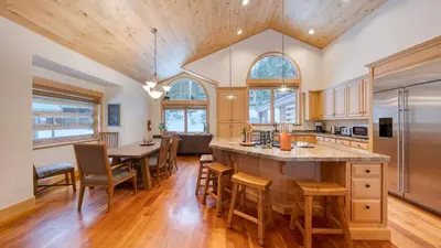 an open kitchen and dining room with a large island at 5 mins to Ski Resort Ping Pong Pool Table Deck Donner Ridge by AvantStay in Truckee