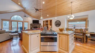 a kitchen and living room with a stove top oven at 5 mins to Ski Resort Ping Pong Pool Table Deck Donner Ridge by AvantStay in Truckee