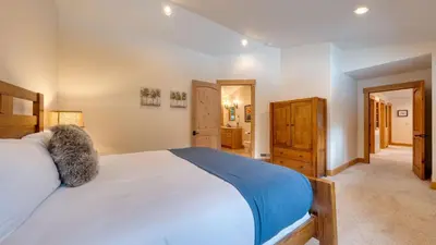 a bedroom with a large bed and a hallway at 5 mins to Ski Resort Ping Pong Pool Table Deck Donner Ridge by AvantStay in Truckee