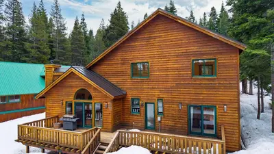a large wooden house with a deck in the snow at 5 mins to Ski Resort Ping Pong Pool Table Deck Donner Ridge by AvantStay in Truckee