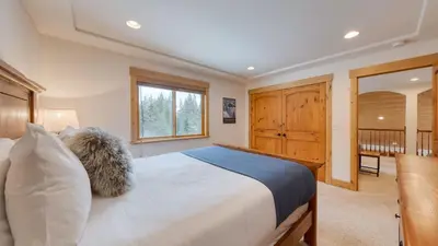 a bedroom with a large white bed in a room at 5 mins to Ski Resort Ping Pong Pool Table Deck Donner Ridge by AvantStay in Truckee