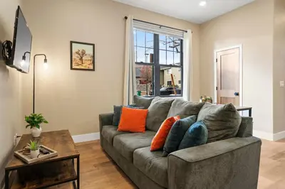 a living room with a gray couch and a table at Luxury Living Modern Midtown Ensuite Baths Patio in Reno