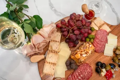 a plate of cheese and fruit on a cutting board at Luxury Living Modern Midtown Ensuite Baths Patio in Reno