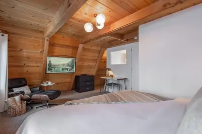 a bedroom with a bed and a wooden ceiling at Mountain Modern The Tahoe A-Frame w Private Pier in Homewood