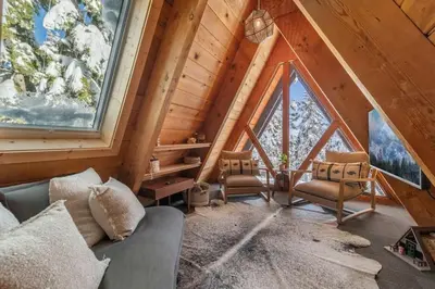 a living room with a couch and some windows at Mountain Modern The Tahoe A-Frame w Private Pier in Homewood