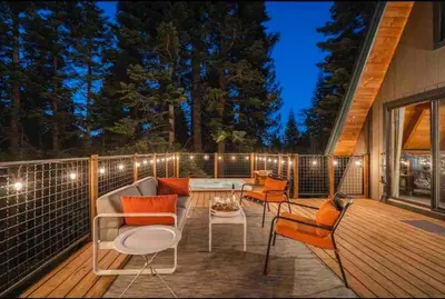 a patio with a table and chairs on a deck at Mountain Modern The Tahoe A-Frame w Private Pier in Homewood