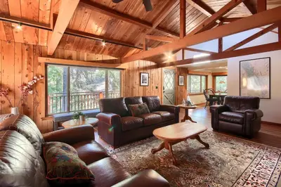 a living room with leather furniture and a wooden ceiling at Tranquility House-Riverfront-Fireplace-Sleeps six in Oakhurst