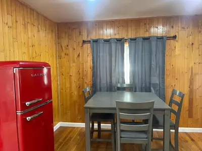 a dining room with a table and a red refrigerator at A Little Bit Of Country in Visalia