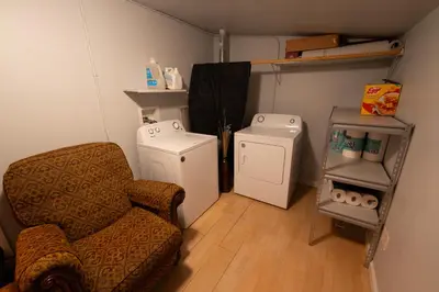 a living room with a chair and a refrigerator at Immersive Stranger Things Experience in Clovis