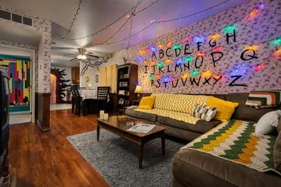 a living room with a couch and a table at Immersive Stranger Things Experience in Clovis