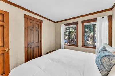a bedroom with a white bed and two windows at 3-Level Incline Village Retreat with Fireplace in Incline Village