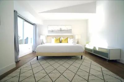 a white bedroom with a bed and a large window at Stunning Waterfront 3BR Retreat - Perfect Getaway in Discovery Bay