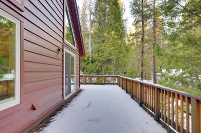 a wooden balcony of a red house with snow on the ground at 5 Mi to Dodge Ridge Cabin in Strawberry in Strawberry