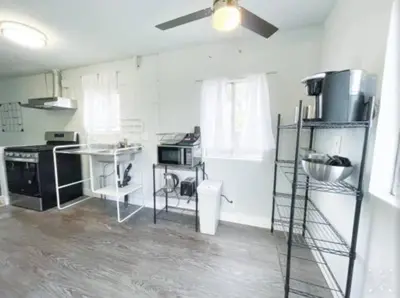 a kitchen with white walls and a ceiling fan at Nifty Trailer With Spacious Parking in Visalia