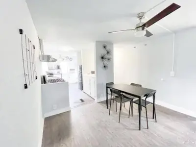 a dining room with a black table and a kitchen at Nifty Trailer With Spacious Parking in Visalia