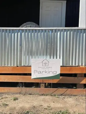 a sign on a fence with a parking sign on it at Nifty Trailer With Spacious Parking in Visalia