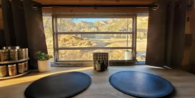 two blue mats on the floor in a room with a large window at Cozy Farm Stay for Two in Three Rivers