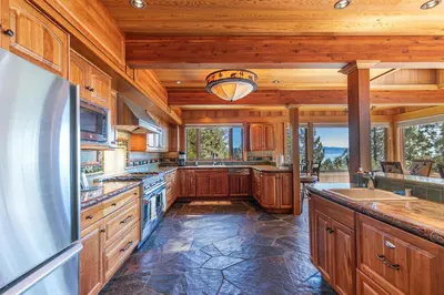 a large kitchen with wooden cabinets and a refrigerator at Clouds Rest in Dollar Point By Tahoe Getaways - Lake views - Hot Tub & Game Room in Tahoe City