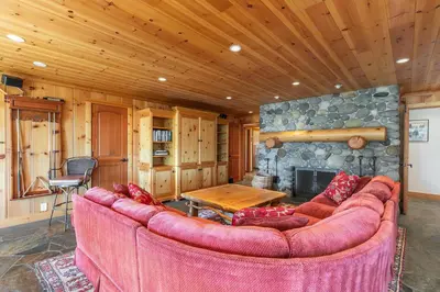 a living room with a couch and a stone fireplace at Clouds Rest in Dollar Point By Tahoe Getaways - Lake views - Hot Tub & Game Room in Tahoe City