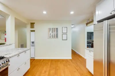 a kitchen with white cabinets and a hardwood floor at Fire Pit and Grill Retreat Between Arnold and Murphys in Hathaway Pines