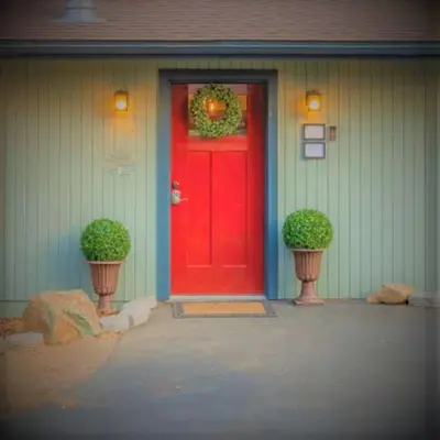 a red door on a house with two potted plants at Cody's Cozy Cottage-Near Yosemite in Mariposa