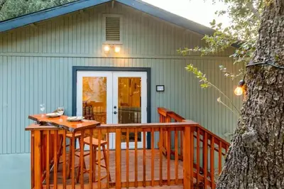 a deck with a table and chairs on a house at Cody's Cozy Cottage-Near Yosemite in Mariposa