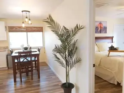 a bedroom with a table and a palm tree in a room at Cody's Cozy Cottage-Near Yosemite in Mariposa