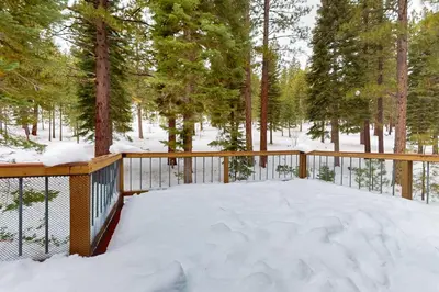 a balcony covered in snow with trees in the background at Wolf Tree Wonder in Truckee