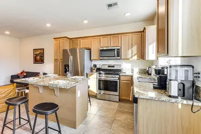 a kitchen with stainless steel appliances and wooden cabinets at 4 Mi to Dtwn Family-Friendly Townhome in Reno in Reno