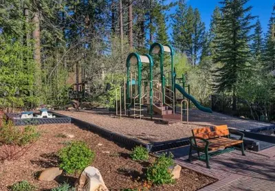 a park with a playground with a bench and a slide at Timber Creek 309 condo in Truckee