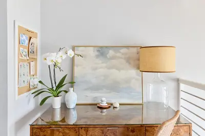 a glass table with a painting and a lamp on it at Marlin Cove Pet Friendly Waterfront Retreat in Discovery Bay