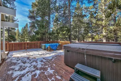 a patio with a hot tub on a deck at 1540TS Snowy Owl Cabin in South Lake Tahoe