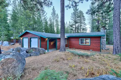 a red cabin in the woods with trees at 1965NP The Bears Den in South Lake Tahoe