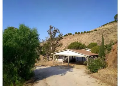 a house with a white roof on a dirt road at Scenic Lake House & Dog Friendly in Wofford Heights