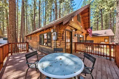 a log cabin with a table and chairs on a deck at Hank Monk Chalet 2730HM in South Lake Tahoe