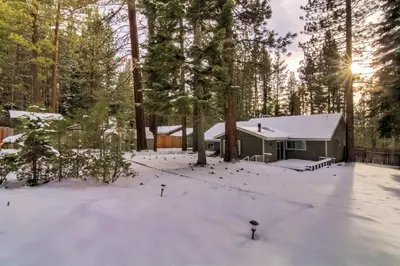 a house in the woods with snow on the ground at 2574C Bear Creek Cabin in South Lake Tahoe