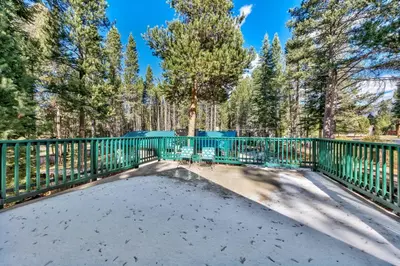 a yard with a green fence and trees at 1207S Cabin in the Pines in South Lake Tahoe