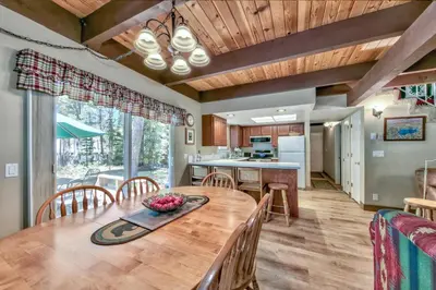 a dining room and kitchen with a wooden table and chairs at 1207S Cabin in the Pines in South Lake Tahoe