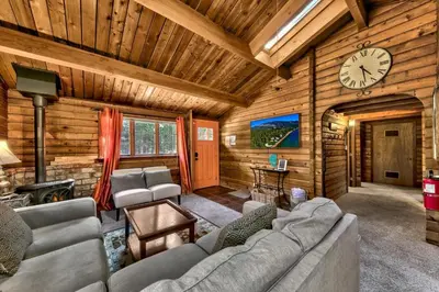 a living room with a couch and a clock on the wall at 1577A The Tahoe Lazy Bear in South Lake Tahoe