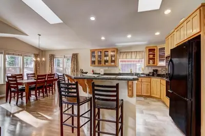 a kitchen with wooden cabinets and a black refrigerator at 1144GB The Golden Bear Retreat in South Lake Tahoe